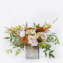 Blush roses and orange mums in a gray wooden box with airy greenery