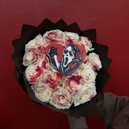 Bouquet of white roses with red splatter accents and a horror movie heart topper