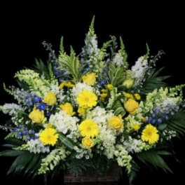 Large yellow and white floral arrangement in a basket