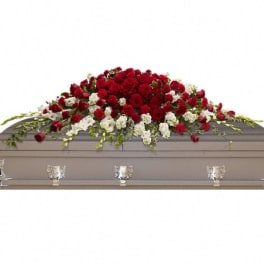 Red and white floral casket spray on a gray casket