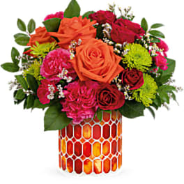 Mixed bouquet of roses and carnations in a patterned glass vase