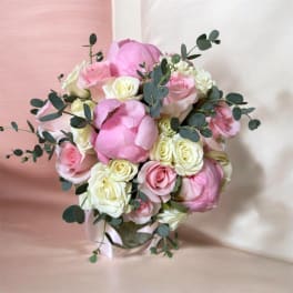 Pink and white rose bouquet with eucalyptus in a clear vase