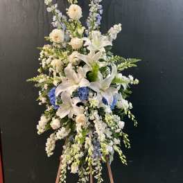 Tall white and blue floral standing spray on an easel