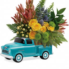 Yellow roses arranged in a turquoise toy truck