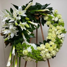 Floral wreath with white lilies, cream roses, and green pom-pom blooms