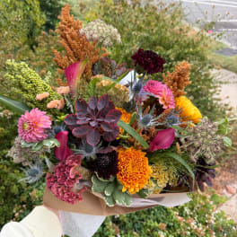 Handheld bouquet with pink, orange, yellow, and burgundy flowers