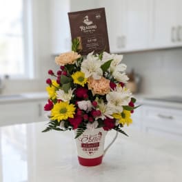 Mixed flower arrangement in a coffee mug with a coffee bag topper
