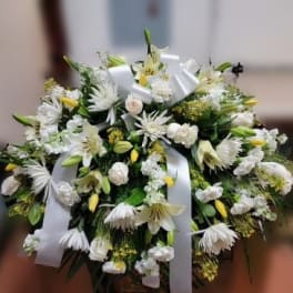 White floral spray with lilies and daisies tied with white ribbon