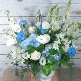 Blue and white floral arrangement in a white vase