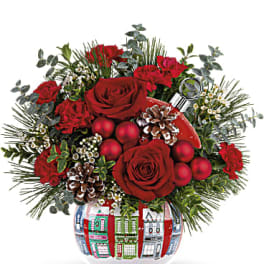 Red roses and carnations in a holiday vase with pinecones and ornaments