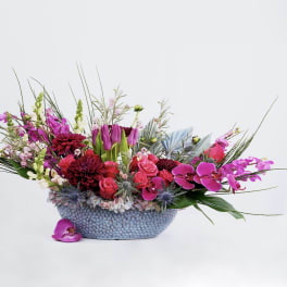 Mixed bouquet in a blue textured bowl with pink and purple flowers