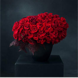 Red rose arrangement in a black vase