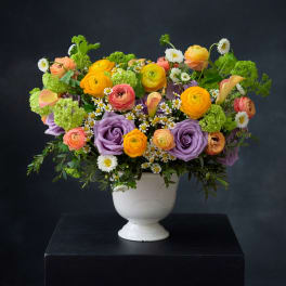 Colorful mixed bouquet in a white pedestal vase