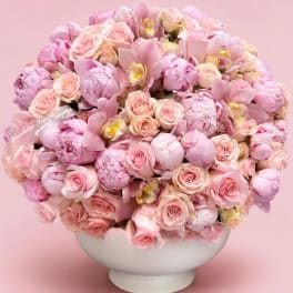 Pink bouquet of roses and peonies in a white bowl vase