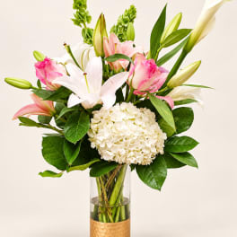 Pink and white lilies with hydrangea in a glass vase