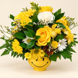 Yellow and white mixed bouquet in a smiley-face vase