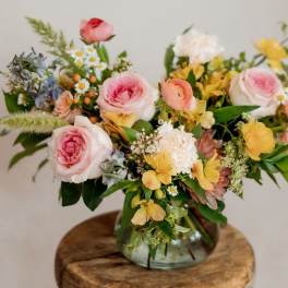Mixed bouquet of pink and yellow flowers in a glass vase