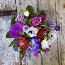Bouquet of purple, pink, and white flowers with orchids and roses