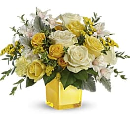 Yellow and white rose bouquet in a square glass vase