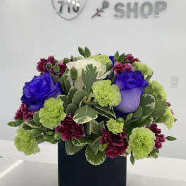 Mixed bouquet of roses and carnations in a black square vase
