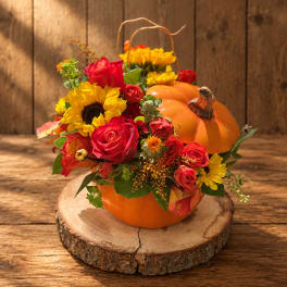 Pumpkin-shaped floral arrangement with red roses and yellow sunflowers