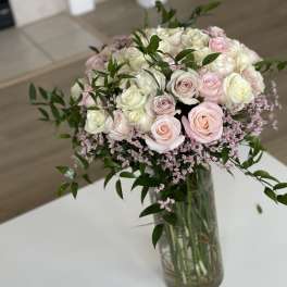 Bouquet of pale pink and white roses in a glass vase