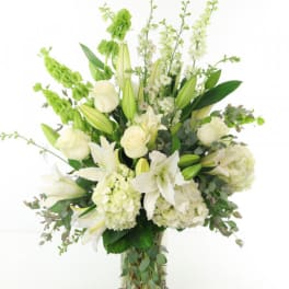 White lilies and roses arranged in a tall vase
