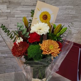 Bouquet of mixed flowers with a sunflower card in clear wrap