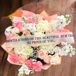 Pink and white mixed flower bouquet with a congratulatory ribbon