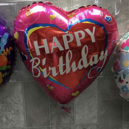 Three birthday balloons in purple, pink, and white.