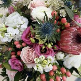 Mixed bouquet with pink and white flowers and a blue thistle bloom