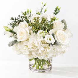 White roses and lisianthus in a clear glass vase