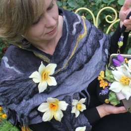 Woman holding a floral handbag decorated with white and purple flowers