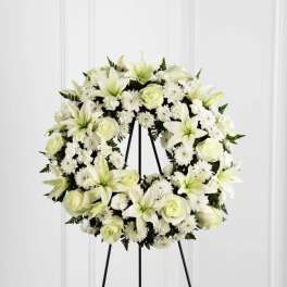 White floral wreath on a black stand
