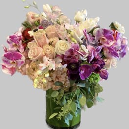 Bouquet of pink and purple flowers in a green glass vase