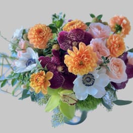 Colorful bouquet with orange dahlias, pink roses, and white anemones