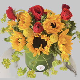 Sunflower and red rose arrangement in a green container