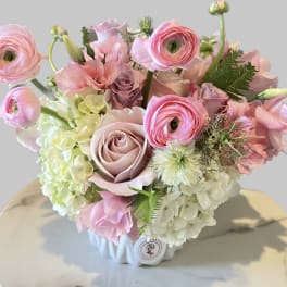 Pink and white floral arrangement in a white vase