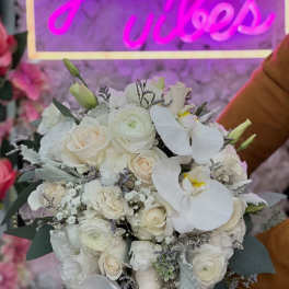 White bridal bouquet with roses, ranunculus, and orchids