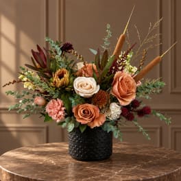 Peach and cream floral arrangement in a black textured vase