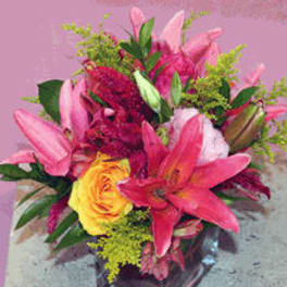 Pink lilies and a yellow rose in a glass vase