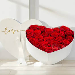 Heart-shaped box of red roses with a matching heart lid reading love