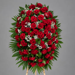 Standing spray of red roses with white baby's breath on an easel