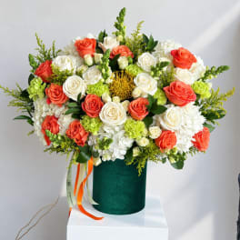 Large bouquet of coral and white roses in a green velvet box