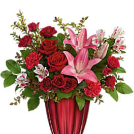 Red roses and pink lilies arranged in a red vase