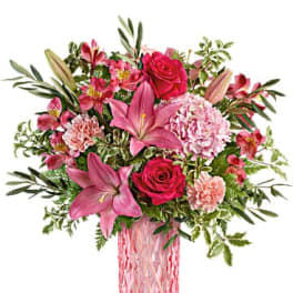 Pink floral arrangement in a tall glass vase