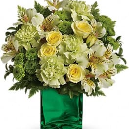 Yellow and white flowers in a green glass vase