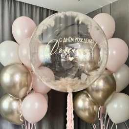 Pastel balloon display with a clear birthday balloon and pink and gold balloons