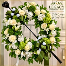 Cream and white floral wreath with green ribbon bows and golf balls