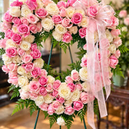Heart-shaped pink and white rose wreath with a sheer ribbon bow